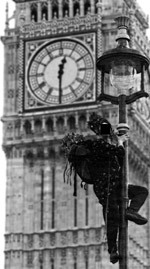 [ Photo of man, smiling, climbing lamppost with Big Ben's clockface in background ]