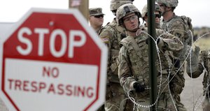 Members of the U.S Army place razor wire for a temporary encampment for the troops near the U.S.-Mexico International bridge, Sunday, Nov. 4, 2018, in Donna, Texas.