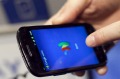 FILE - In this Jan. 17, 2012 file photo, a person tries a smartphone loaded with Google Wallet at the National Retail ...