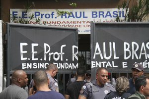 Police officers guard the entrance of the Raul Brasil State School in Suzano, Brazil, Wednesday, March 13, 2019.