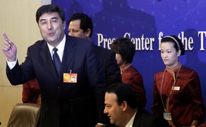 Nur Bekri, governor of Xinjiang autonomous region, reacts next to Urumqi Mayor Jerla Isamudinhe, center bottom, as they leave after a press conference on the sidelines of the National People's Congress in Beijing, China, Sunday, March 7, 2010.