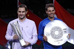 Winner's Roger Federer of Switzerland, left, holding the winner's trophy and Rafael Nadal of Spain pose with their trophies after the award ceremony for the Shanghai Masters tennis tournament at Qizhong Forest Sports City Tennis Center in Shanghai, China, Sunday, Oct. 15, 2017.