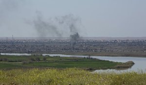 A column of smoke from operations by  U.S.-backed Syrian Democratic Forces (SDF) in  Baghouz, the Islamic State group's last pocket of territory in Syria, Wednesday, March 20, 2019. (AP Photo/Maya Alleruzzo)