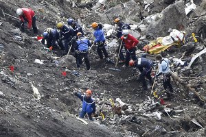 In this Thursday March 26, 2015 file photo, rescue workers inspect the debris from the Germanwings jet at the crash site near Seyne-les-Alpes, France.