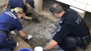 Investigators comb through the former property of Roxlyn Bowie.