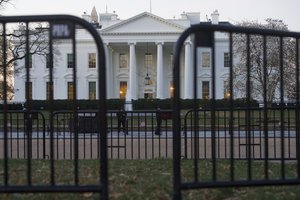 The White House is seen behind security barriers in Washington, Sunday, March 24, 2019.