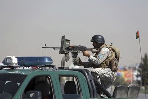 An Afghan security officer mans with gun near a house where attackers are hiding, in Kabul, Afghanistan, Tuesday, Aug. 21, 2018.