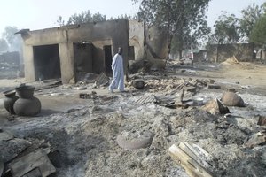 In this Sunday Jan. 31, 2016 file photo, a man walks past burnt out houses following an attacked by Boko Haram in Dalori village near Maiduguri.