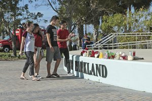 PARKLAND, Fla. (AP) — Students place flowers on the stage outside Pines Trail Center where a candlelight vigil will be held at 6:00 PM. A law enforcement official says the former student suspected of killing at least 17 people at a Florida high school posted