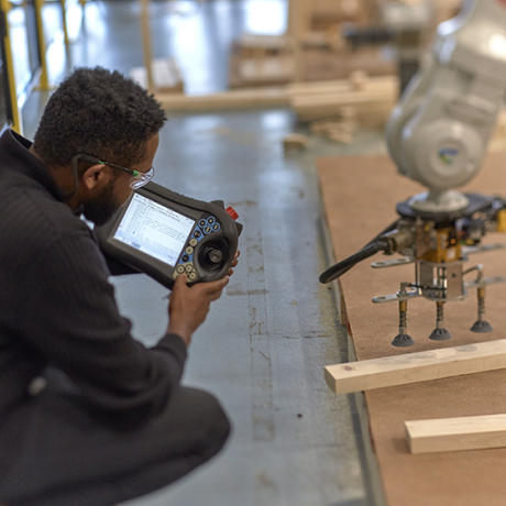 Worker observing machinery while using a handheld computer