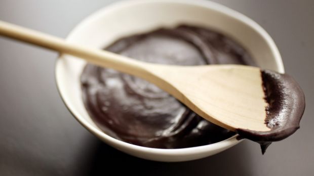 Chocolate icing, bowl of with wooden spoon.