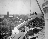 Construction of Natural History Building, workmen set the last stone on the south porch