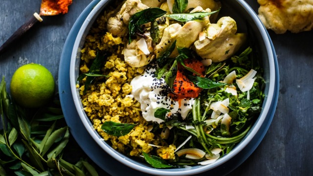 Far from blah: Colourful Sri Lankan curry-poached chicken and rice with salad, condiments and optional naan bread.