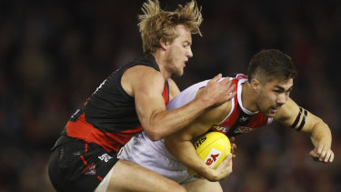 Jade Gresham of the Saints is tackled by Darcy Parish of the Bombers 