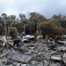 Heather and Bill Armstrong sift through the ashes of Beverley Wells' home, which was lost in the Bunkers Hill fire.  