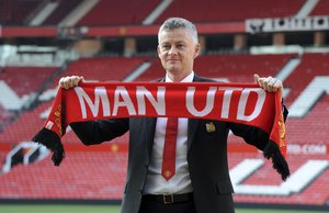 Manchester United soccer team manager Ole Gunnar Solskaer holds a team scarf as he is unveiled as permanent Manchester United manager at Old Trafford, England, Thursday, March 28, 2019.