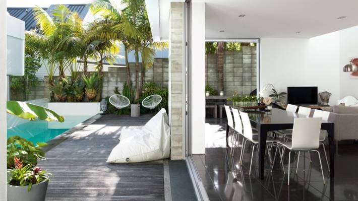 The floor-to-ceiling glass doors slide right back to let the outside in at Laurinda and Brent Sutcliffe's homein Auckland's Herne Bay. 
