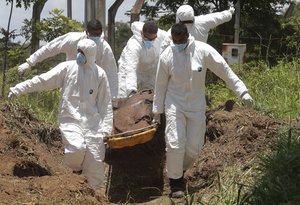 Rescue workers carry away a body they pulled from the mud after a dam collapsed and flooded Brumadinho, Brazil, Monday, Jan. 28, 2019.