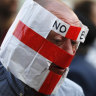 A Brexit supporter wears a paper mask with the colors of the England flag and the words "No EU" in Westminster, London.