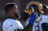 Los Angeles Rams defensive end Aaron Donald puts his helmet on after a stretching period during practice for the NFL ...
