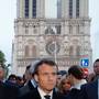 French President Emmanuel Macron walks near the Notre Dame Cathedral as its burns in Paris, France, April 15, 2019. REUTERS/Philippe Wojazer