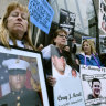 Kathleen Scarpone, left, and Cheryl Juaire, second from left, protest at Harvard University last week. Juaire, who's son Corey Merrill died of in 2011, led a demonstration by parents who have lost a child to opioid abuse. 