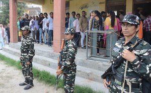 Indian Border Security Force (BSF) soldiers stand guard as villagers queue up to cast their votes at a polling station in Suchetgarh village of Ranbir Singh Pora sector near the India-Pakistan international border, around 25km from Jammu, India, 11 April 2019.