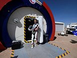 A guide wearing a space suit stands at an entrance to "Mars Base 1" in the Gobi desert in China