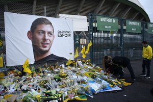 Nantes soccer team supporters lay flowers at a poster of Argentinian player Emiliano Sala and reading "Let's keep hope" outside La Beaujoire stadium before the French soccer League One match Nantes against Saint-Etienne, in Nantes, western France, Wednesday, Jan.30, 2019