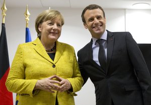 German Chancellor Angela Merkel, left, and French President Emmanuel Macron pose for photographers prior to a meeting on the sidelines of an EU summit at the Europa building in Brussels on Thursday, Dec. 14, 2017.