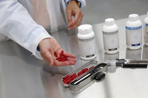 FILE - In this June 17, 2015 file photo, Dr. Andrew Bachman holds the pill form of medical marijuana during a tour of LeafLine Labs, a medical marijuana production facility, in Cottage Grove, Minn.