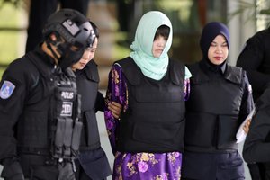 Vietnamese Doan Thi Huong, center, is escorted by police as she leaves court after hearing at Shah Alam High Court in Shah Alam, Malaysia, Thursday, June 28, 2018.