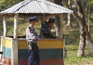 Myanmar police officers stand guard at the border fence near the Taungbro bridge road leading to newly-built repatriation camps prepared for Rohingya refugees expected to be returing from Bangladesh, Wednesday, Jan. 24, 2018, in Taungpyo township, Maung Daw district, border town of northern Rakhine State, Myanmar.