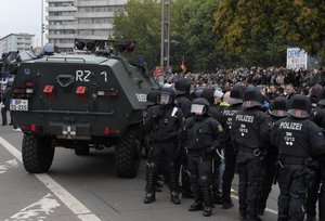 Police beside an armored car as they separate right wing and left wing protestors in Chemnitz, eastern Germany, Saturday, Sept. 1, 2018, after several nationalist groups called for marches protesting the killing of a German man last week, allegedly by migrants from Syria and Iraq.