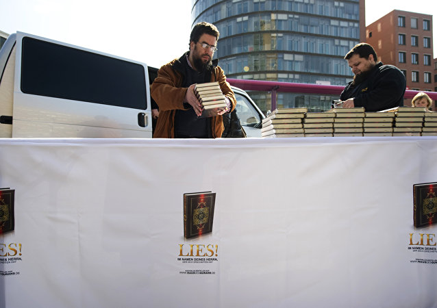 Supporters of the Salafist group House of the Quran (Haus vom Karan) give out Korans at Potsdamer Plarz in Berlin on April 14, 2012. The banner reads: Read! in the name of your Lord