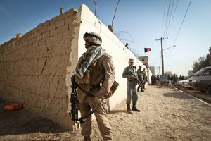 U.S. Marine Corps Cpl. Josh Williams, a supply clerk assigned to an Afghan police mentoring team, provides security alongside Afghan policemen in Zaranj, Nimroz province, Afghanistan