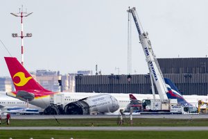 A crane works at the site of the damaged Sukhoi SSJ100 aircraft of Aeroflot Airlines in Sheremetyevo airport, outside Moscow, Russia, Monday, May 6, 2019.