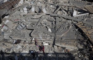 Palestinians check the damage of a multi-story building following Israeli airstrikes in Gaza City, Sunday, May 5, 2019.