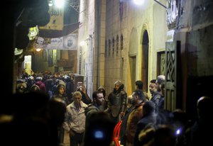 Policemen and residents surround the site of an explosion in the Gamaliya district, near Cairo's famed Khan el-Khalili tourist marketplace in Cairo, Egypt, late Monday, Feb. 18, 2019