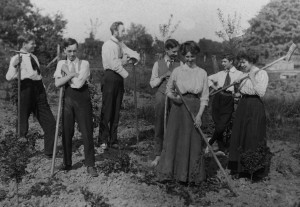 On a farming holiday in an English utopian community, probably around 1910. Men and women pose with rakes and hoes. 