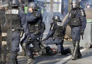 Riot police officers detain a protester during a demonstration Saturday, Feb.16, 2019 in Paris.