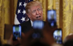 People in the audience hold up their smart phones as President Donald Trump speaks during the National African American History Month reception in the East Room of the White House in Washington, Tuesday, Feb. 13, 2018.