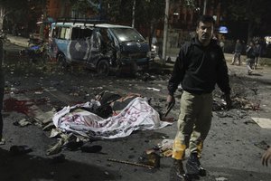 A police commando stands alert at the site of a deadly bombing, in Lahore, Pakistan, Monday, Feb. 13, 2017. Pakistani police say a large bomb has struck a protest rally in the eastern city of Lahore, killing many people and wounding others. A local police official said the blast occurred when a man on a motorcycle rammed into the crowd of hundreds of pharmacists, who were protesting new amendments to a law governing drug sales. (AP Photo/K.M. Chaudhry)