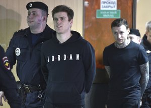 Zenit St. Petersburg soccer team striker Alexander Kokorin, second left, and Krasnodar's midfielder Pavel Mamayev arrive for a hearing in a court in Moscow, Russia, Wednesday, April 3, 2019