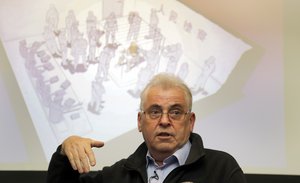 British investigator, Peter Humphrey, addresses the media in front of a screen showing a TV interview situation with him, during a press conference in London, Friday, Nov. 23, 2018.