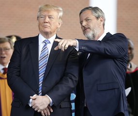 President Donald Trump stands with Liberty University president, Jerry Falwell Jr., right, during commencement ceremonies at the school in Lynchburg, Va., Saturday, May 13, 2017.