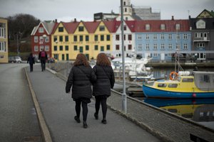 Two women, walk beside the harbor, in Torshavn, the capital city of the Faeroe Islands, Wednesday, March 18, 2015.