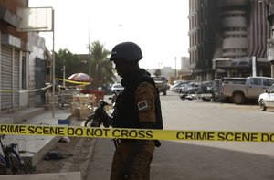 A soldier stand guards outside the Splendid Hotel in Ouagadougou, Burkina Faso, Saturday, Jan. 16, 2016.