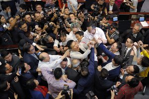 Pro-democracy and pro-Beijing lawmakers scuffle in the chamber at Legislative Council in Hong Kong, Saturday, May 11, 2019