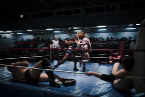 In this photo dated Saturday, Feb. 24, 2018, wrestlers Delia, center left, and Camille fight during a wrestling charity gala in Ivry-sur-Seine, south of Paris, France.